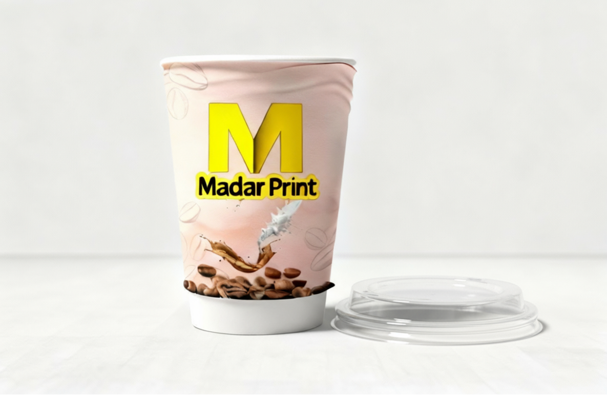 كوب قهوة وردي للاستخدام مرة واحدة بشعار "مدار برنت"، يتميز بتصميم حبوب القهوة وغطاء شفاف.