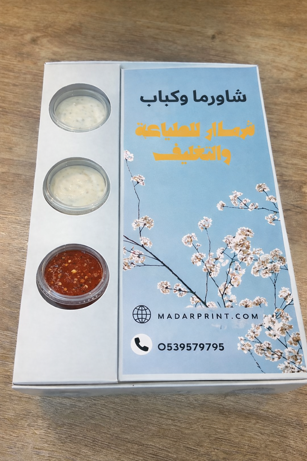 Product packaging with floral design and text on a wooden surface