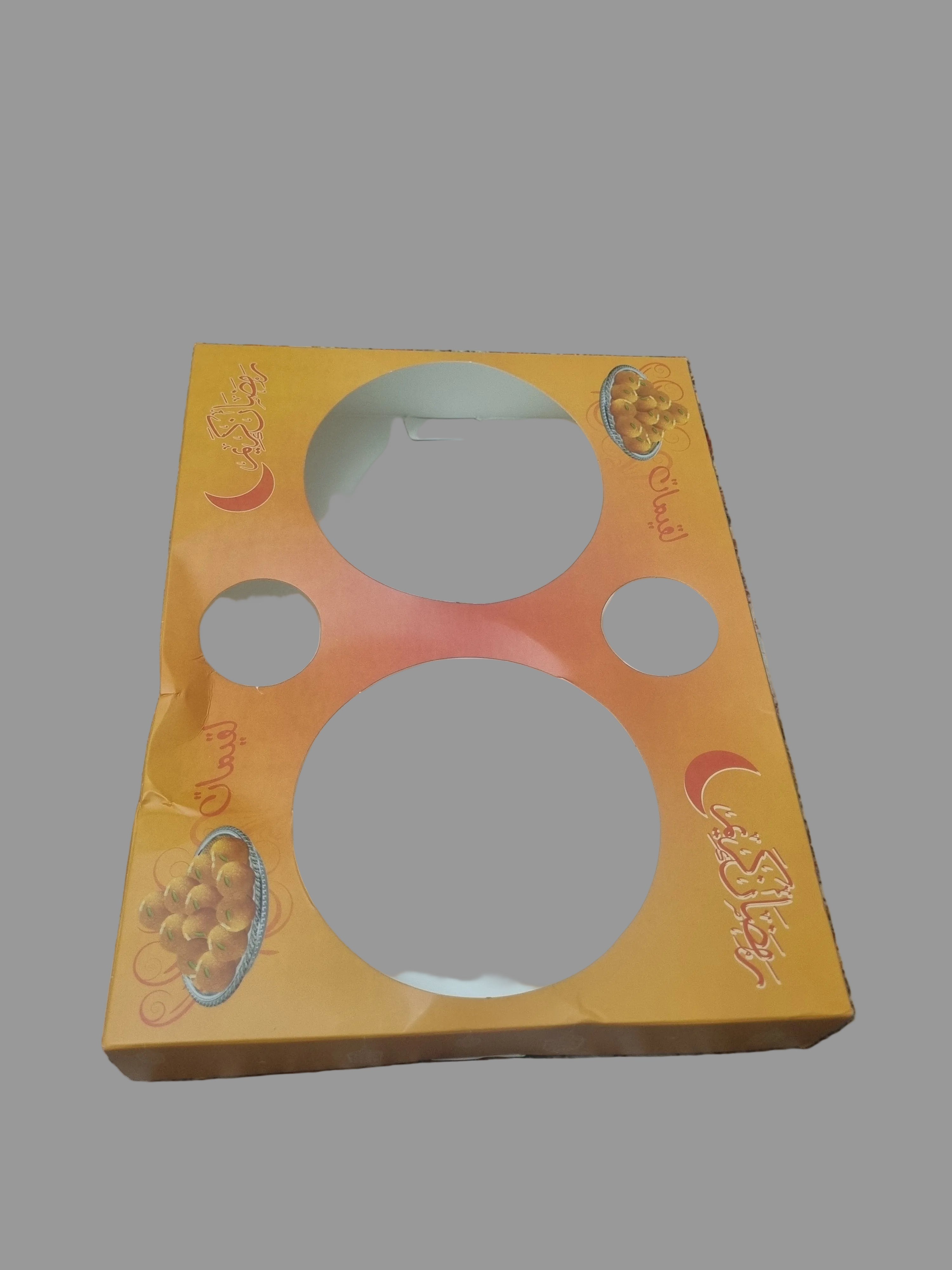 Orange packaging with white circular items on a patterned fabric background