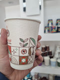 Gobelet à café écologique en papier avec des motifs géométriques colorés, idéal pour les boissons chaudes.