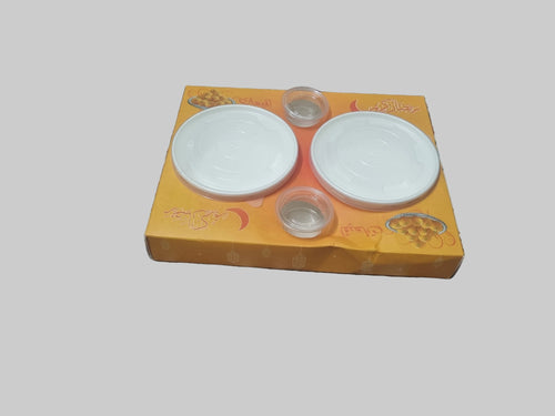 Two weiß ceramic plates on a yellow Box mit floral Design on a patterned fabric background