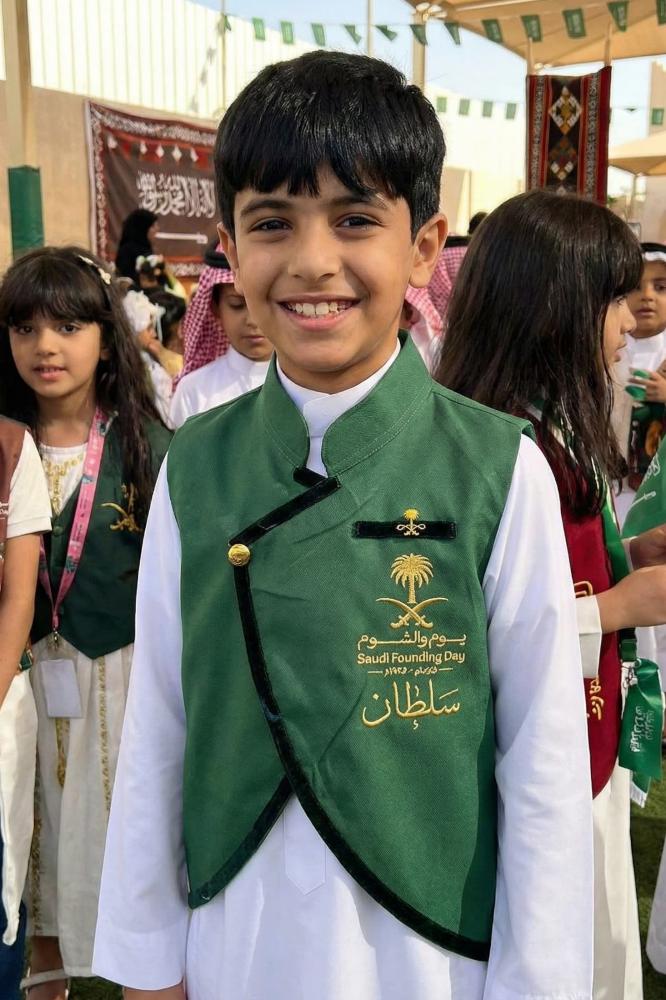 A plain green boys' blazer with a Saudi standing collar and a curved cut, with a brooch of two swords and a palm tree — product image 2