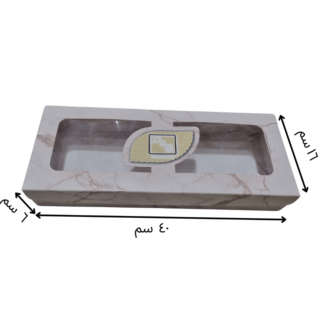  مواصفات البوكس 
الطول40 سم العرض 16 سم الارتفاع 6 سم 
يحتوي البوكس على شباك شفاف يمنحه الجمالية وإمكانية رؤية ما بداخل البوكس  
البوكس يصلح للحلويات والمخبوزات والعديد من الاستعمالات الأخرى التي يتناسب مقاسها مع حجم البوكس وتفاصيله 



الطباعة:
يمكنكم طلب طباعة خارجية فقط أو داخلية وخارجية 
السولوفان:
السولوفان هو طبقة نايلون عازلة تفيد في 1- يمنح المتانة للعلبة
2- يعزل الزيوت والسوائل عن الورق
3- يمنع الطباعة من الاختلاط بالمواد الغذائية 
لكم حرية الاختيار بإضافة سولوفان خارجي فقط أم داخلي فقط أم على الجا