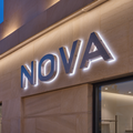 Custom reverse-lit aluminium 3D letters with white halo illumination on a stone storefront facade