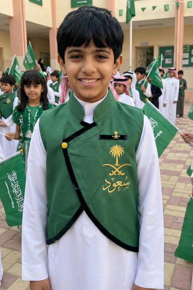 A plain green boys' blazer with a Saudi standing collar and a curved cut, with a brooch of two swords and a palm tree — product image 1