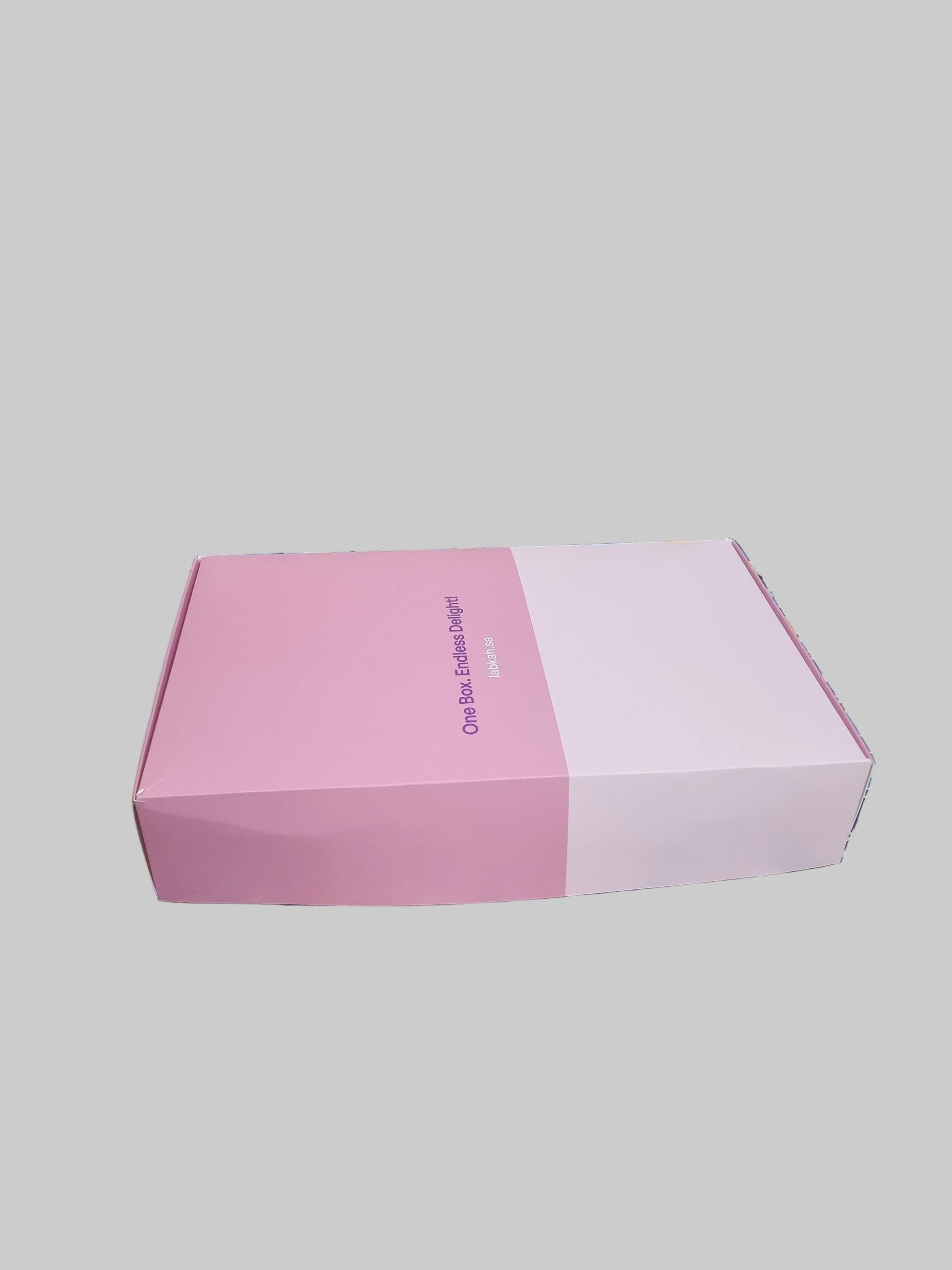 Colorful patterned box with a pink interior on a textured surface