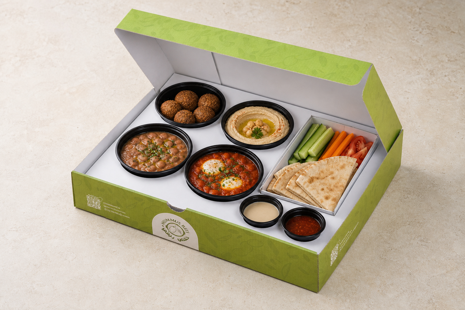 Open green catering meal box filled with falafel, hummus, foul, shakshouka and vegetables