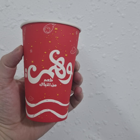 Red disposable paper cup with vibrant design, perfect for hot beverages or party use.