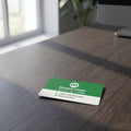 Small full-color ID card with vibrant design placed on textured dark wooden desk in an office setting.